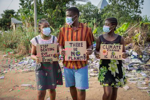 African youth protesting against climate change holding signs and wearing masks photo
