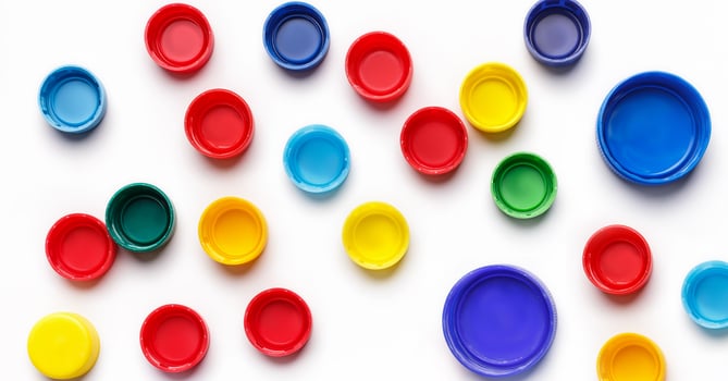 Colored plastic bottle's covers on white background, top view, photo