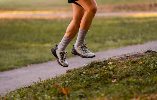Cropped image of a sporty running man in cross country trail run. photo