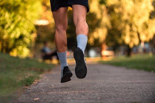 Close up of male athlete runner feet running on road, Jogging concept at outdoors. Man running for exercise. Active healthy lifestyle. photo