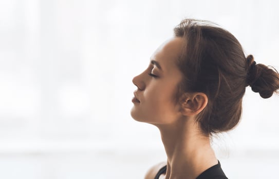 Wellness Concept. Profile Portrait Of Girl With Beam Closing Her Eyes, Breathing Over White Wall. Studio Shot, Copyspace photo