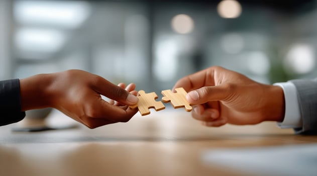 Two people holding a piece of puzzle together photo