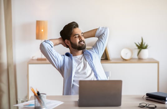Relaxed Eastern Man Leaning Back In Chair, Resting After Online Work With Laptop, Millennial Arab Guy Sitting At Table With Computer In Home Office With Hands Behind Head And Looking Aside, Free Space photo
