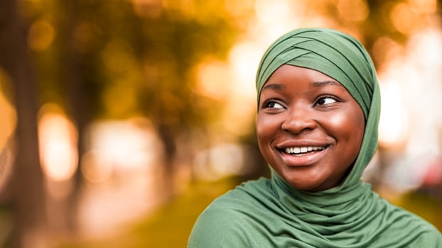 Closeup Portrait Of Beautiful Smiling African Islamic Woman In Hijab Standing Outdoors On Street, Cheerful Black Muslim Lady In Stylish Headscarf Looking Away, Selective Focus With Copy Space photo