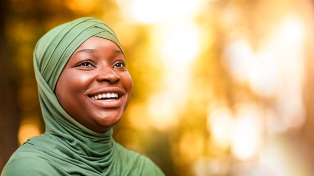 Portrait Of Laughing Black Muslim Lady In Hijab Standing Outdoors, Closeup Shot Of Happy Positive African Islamic Woman In Headscarf Looking Away And Sincerely Smiling, Selective Focus With Copy Space photo