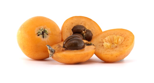 Fresh loquats, whole and cut, showing seeds, on white background photo