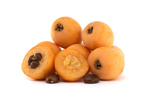 A delightful pile of fresh, ripe loquats, showing both whole and cut sections. photo