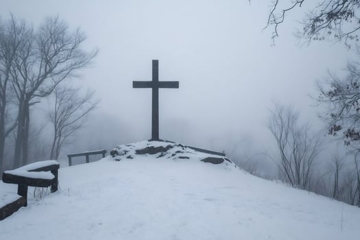 Large cross standing on snowy hill during foggy winter day photo