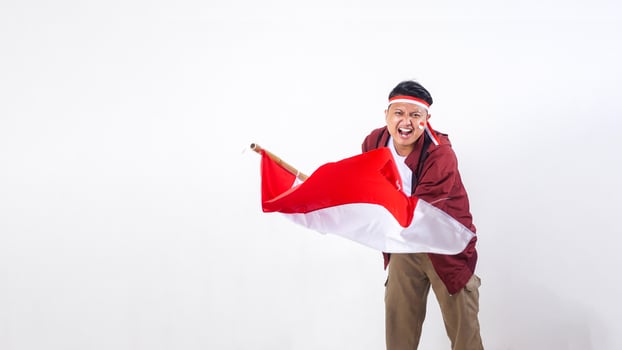 Indonesian man holding stick with red and white flag of Indonesia with spirit to celebrate Indonesia independence day isolated on white background photo