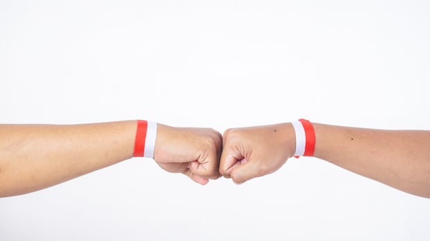 Two men with red and white wristband doing fist bump isolated on white background photo
