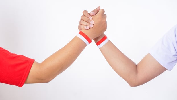 Two men with red and white wristband doing unity handshake isolated on white background photo