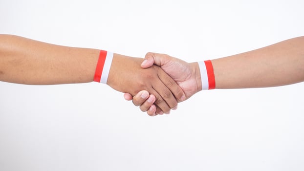Two men hands with red and white wristband doing handshakes isolated on white background photo