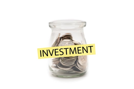 Coins in glass money jar with INVESTMENT word on label, Financial Concept. isolated on white background. Money Investment and Financial Security. photo