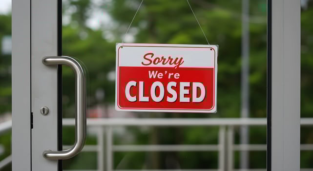 Red and White Closed Sign Hanging on a Glass Door Handle photo