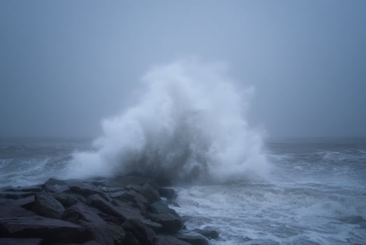 Powerful Waves Crashing Against Rocks on a Stormy Coastline photo