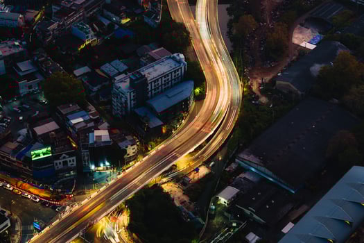 Light on expressway passing crowded downtown during dawn photo