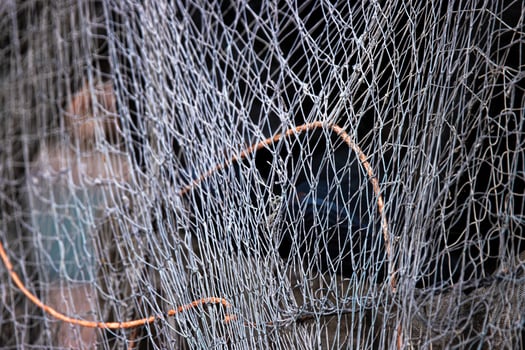 Fisher equipment. A weathered folded fishing hoop net and coiled wire and ropes on the ground, 07 photo