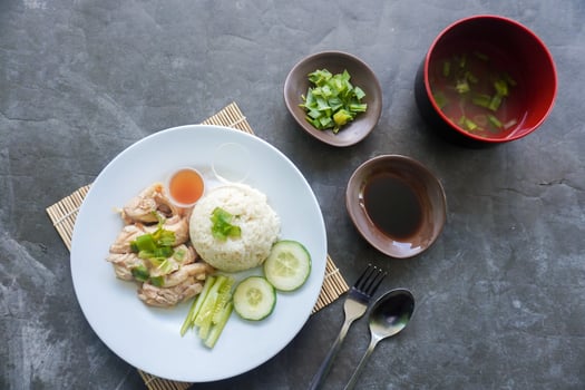 Hainanese chicken rice or nasi hainan or rice steamed with chicken soup served with cucumber slice,,, photo