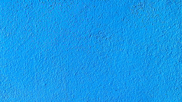 Bright Blue Textured Wall Surface with Subtle Shadows and Rough Finish for Background or Design Element photo