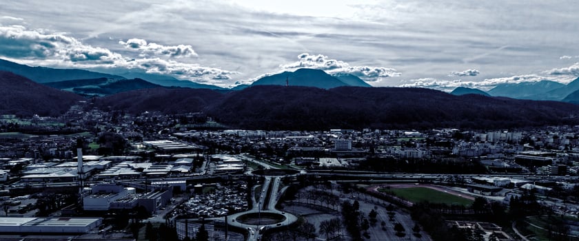 Moody aerial view of a valley city at dusk with silhouetted hills and mountains photo