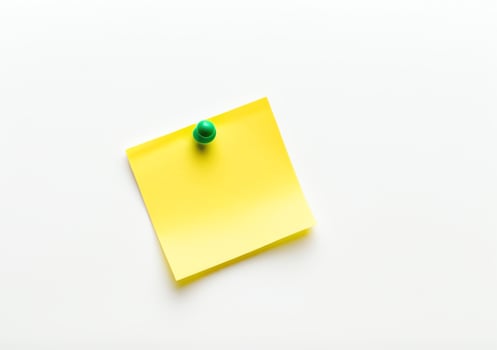 Yellow sticky note with green push pin isolated on white background in high definition photo