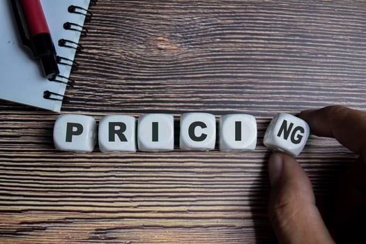 male hand presses the Pricing on dice or wooden cubes photo