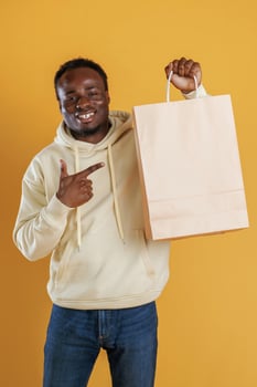 Bag with copy space, conception of shopping. Black guy is against yellow background photo