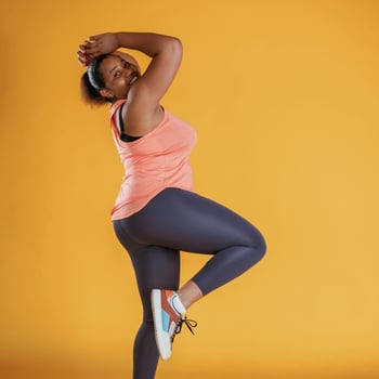 Standing and posing. African American,woman is in the studio against yellow background photo