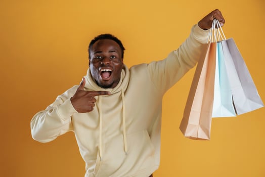 Crazy, sales, with shopping bags. Black guy is against yellow background photo