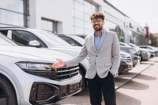 Car salesman showing a new car in car dealership photo