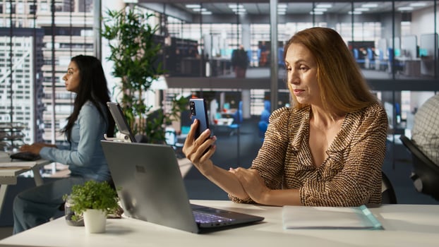 Businesswoman participates in a virtual meeting via call, discussing project objectives and financial planning. Female executive uses her laptop for remote business communication. Camera B. photo