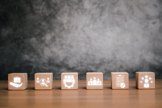Wooden blocks symbolize assessment center concepts like teamwork, evaluation, and business strategy on a textured background. photo