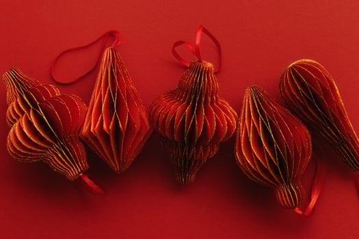 Shiny Red Paper Christmas Ornaments, winter seasonal holiday decorations on red background, copyspace, Happy New Year holiday minimal backdrop, vivid dark color. Top view handmade Christmas bauble photo