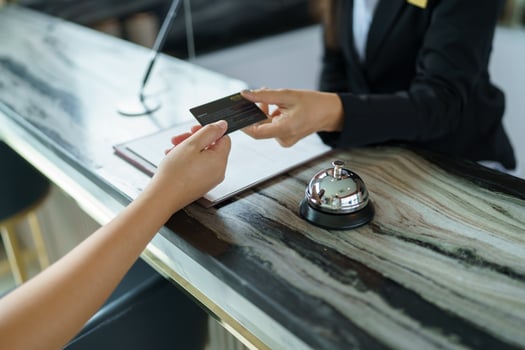 Hotel receptionist in uniforms Concierge giving the key doing check in at the hotel desk in lobby photo