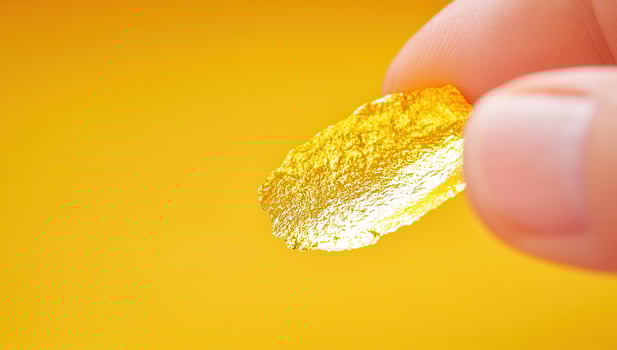 Close Up of Hand Holding Shiny Gold Foil photo