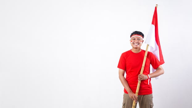 Indonesian man celebrate Indonesia independence day on August 17 by holding the Indonesian flag isolated on white background photo