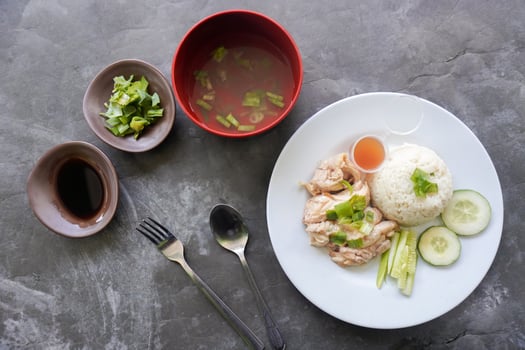 Hainanese chicken rice or rice steamed with chicken soup served photo