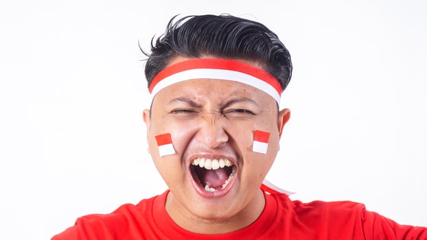 Close up portrait of Indonesian man with red and white attributes celebrate independence day of Indonesia on August 17 isolated on white background photo