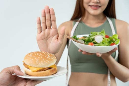 Beauty slim female body confuse hamburger. Woman chooses salad for achieves weight loss goal for healthy life, crazy about thinness, thin waist, nutritionist. Diet, body shape. photo