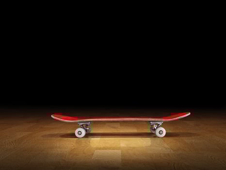 Red skateboard on gym floor, black background. photo