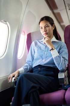 Business travel. Thoughtful woman seated in airplane photo