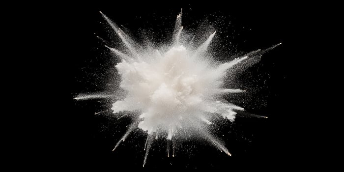 Dynamic flour explosion against black background photo