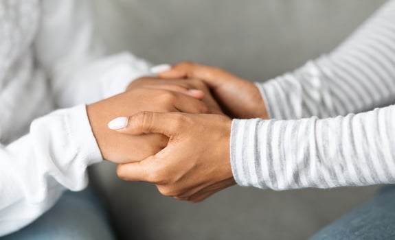 Cropped of black mother holding daughter hands, closeup. Unrecognizable african american mom and kid cuddling. Motherhood, parenthood, supportive family, mother love and protection concept photo