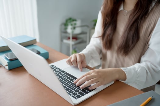 a woman typing on a laptop computer photo