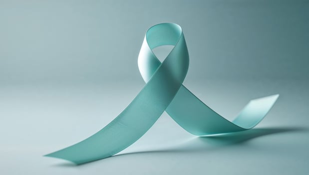 Teal ribbon on light blue background symbol of awareness and support photo
