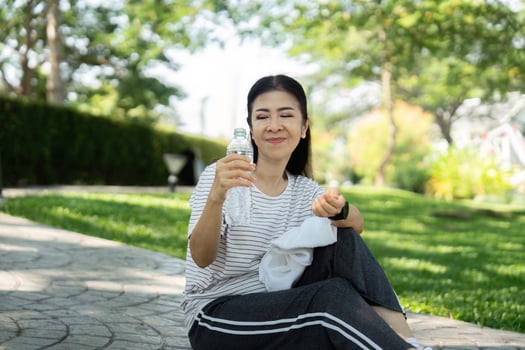 Wellness and joy. Elderly woman enjoying water in the park photo