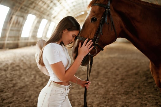 Embracing the animal. Beautiful ,young woman is with horse indoors photo