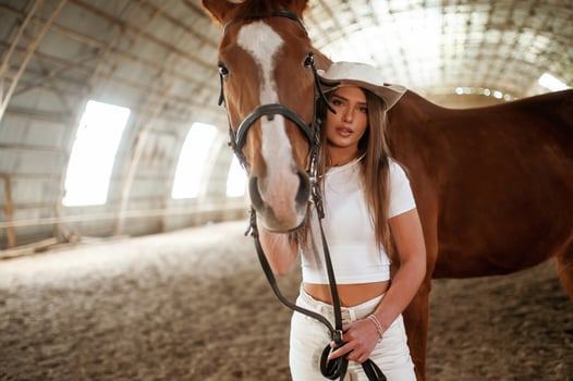Looking forward.. Beautiful ,young woman is with horse indoors photo