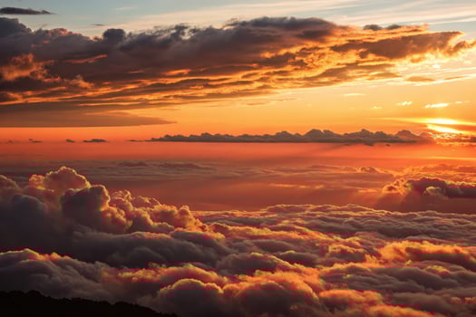 Golden lit clouds blanket the horizon at sunset creating a warm cinematic atmosphere photo