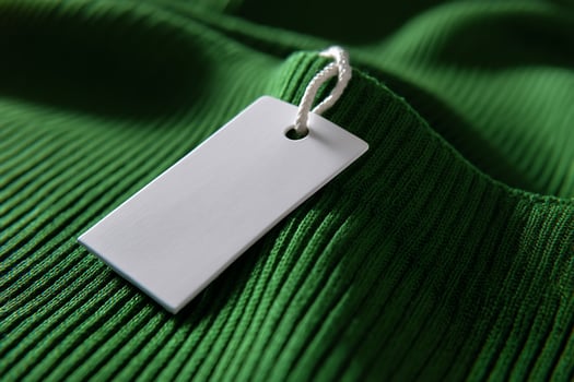 Blank price tag on emerald green ribbed fabric photo